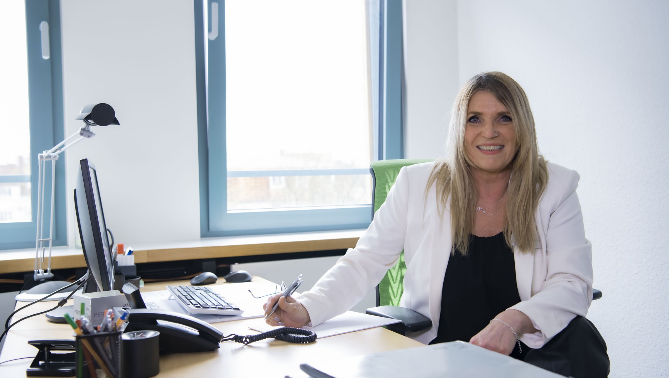 Frau im Büro blickt in die Kamera