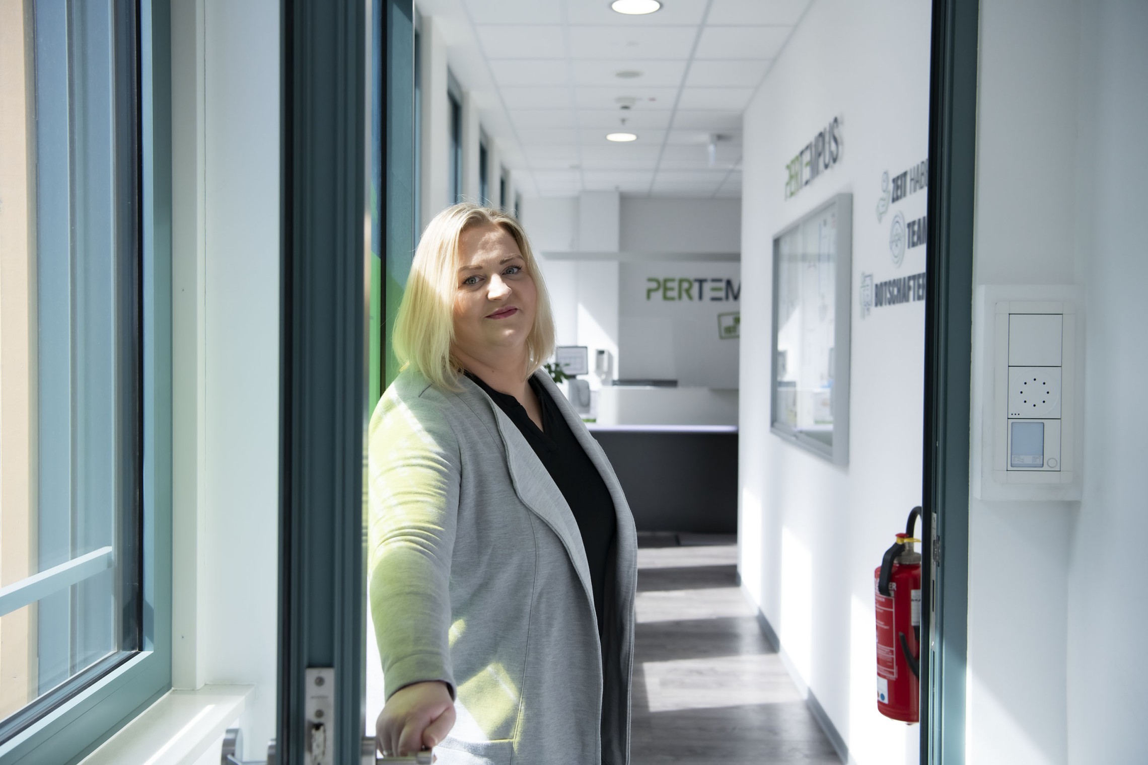 Frau öffnet die Tür für Besucher
